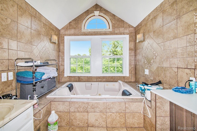 7471 Brewer Rd, Flint, MI 48507 - full bathroom with vanity, a tub with jets, healthy amount of natural light, lofted ceiling, and tile walls