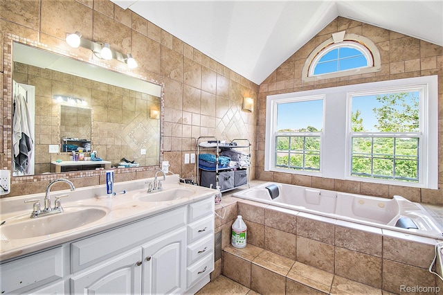7471 Brewer Rd, Flint, MI 48507 - bathroom featuring plenty of natural light, vaulted ceiling, double vanity, a bath, and tile walls