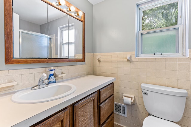 771 S Venoy Rd, Westland, MI 48186 - full bathroom with vanity, healthy amount of natural light, a shower with door, tile walls, and wainscoting