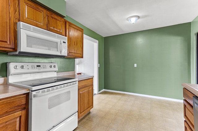 771 S Venoy Rd, Westland, MI 48186 - kitchen featuring white appliances, light countertops, and brown cabinetry