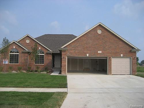 39229 Jefferson Ave, Harrison Township, MI 48045 - view of front of home featuring an attached garage, concrete driveway, a front yard, and brick siding