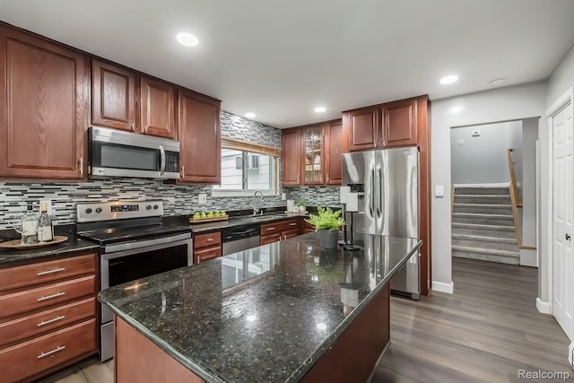 4290 Frostwood, Troy, MI 48098 - kitchen featuring stainless steel appliances, tasteful backsplash, light wood finished floors, glass insert cabinets, and a center island