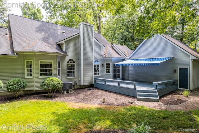 8123 Baypointe Dr, Brighton, MI 48114 - back of property with a deck, a chimney, roof with shingles, and a lawn