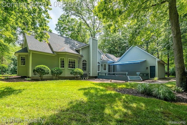 8123 Baypointe Dr, Brighton, MI 48114 - back of property featuring a lawn, a chimney, and roof with shingles