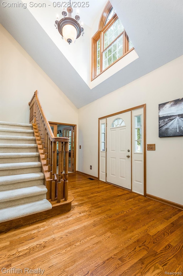 8123 Baypointe Dr, Brighton, MI 48114 - entryway with healthy amount of natural light, stairway, high vaulted ceiling, and light wood finished floors
