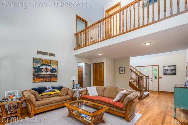 8123 Baypointe Dr, Brighton, MI 48114 - living area with stairs, light wood finished floors, a towering ceiling, and recessed lighting