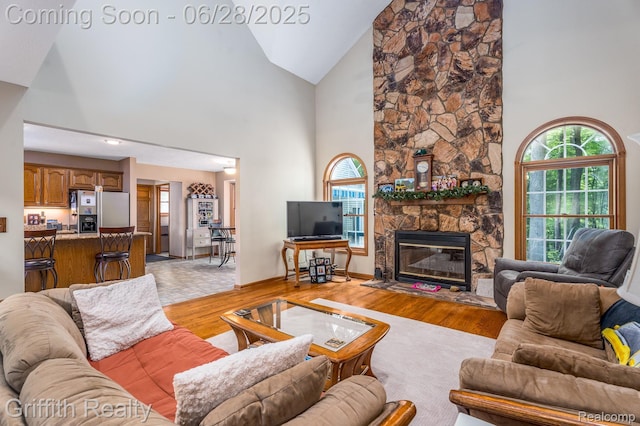 8123 Baypointe Dr, Brighton, MI 48114 - living room featuring high vaulted ceiling, light wood-type flooring, and a fireplace
