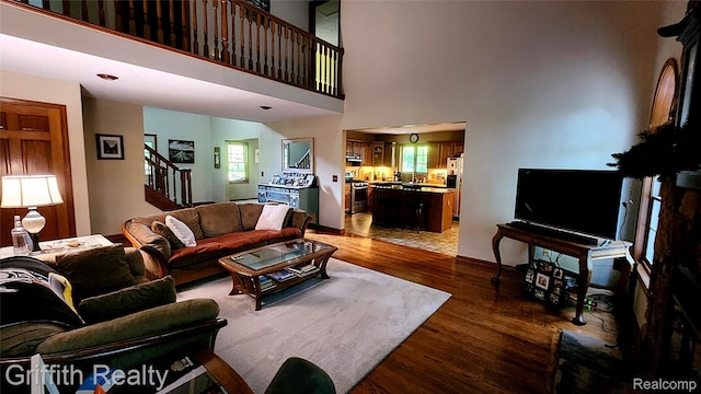 8123 Baypointe Dr, Brighton, MI 48114 - living area with stairs, light wood-style flooring, plenty of natural light, and a high ceiling