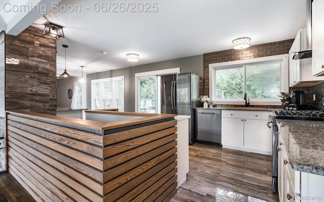 2905 Lahser Rd, Bloomfield Hills, MI 48304 - kitchen with stainless steel appliances, white cabinets, dark wood finished floors, and hanging light fixtures