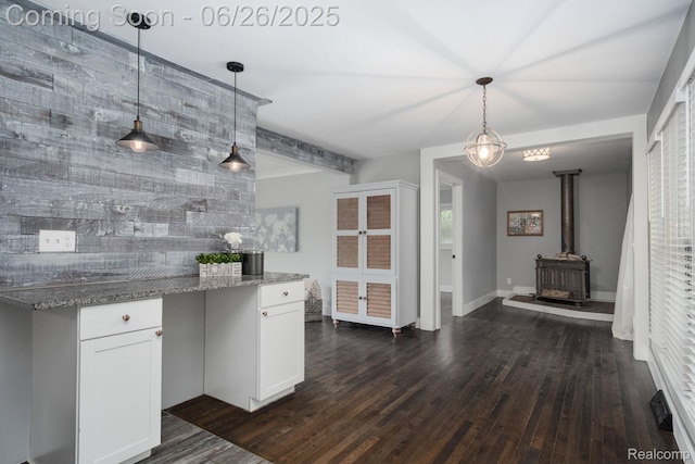 2905 Lahser Rd, Bloomfield Hills, MI 48304 - kitchen with dark wood-type flooring, white cabinetry, stone countertops, a wood stove, and beam ceiling