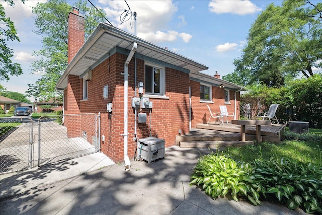 13210 Tecumseh Ave, Redford, MI 48239 - view of home's exterior with a chimney, a gate, and brick siding