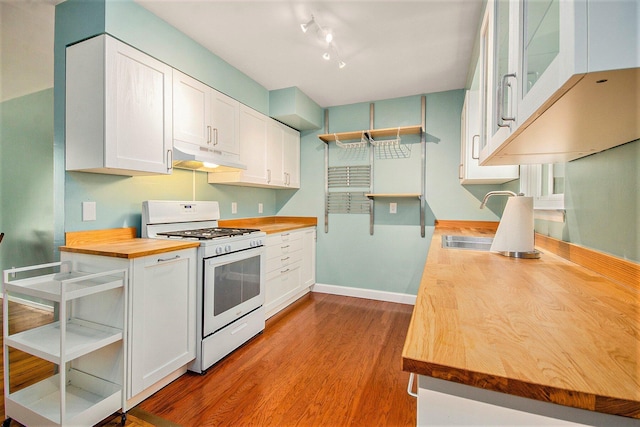 1621 Whittier Rd, Ypsilanti, MI 48197 - kitchen featuring gas range gas stove, butcher block counters, under cabinet range hood, dark wood finished floors, and white cabinets
