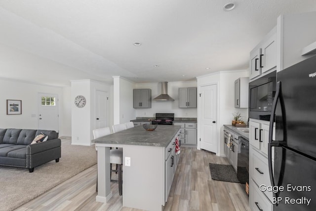 19150 Yankee Rd, Morley, MI 49336 - kitchen with black appliances, wall chimney range hood, dark countertops, a breakfast bar, and recessed lighting