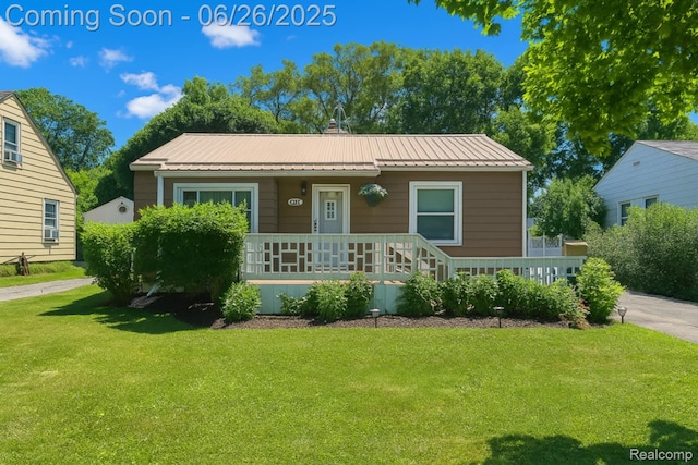 607 Chalmers St, Flint, MI 48503 - bungalow with a porch, a front lawn, and a metal roof
