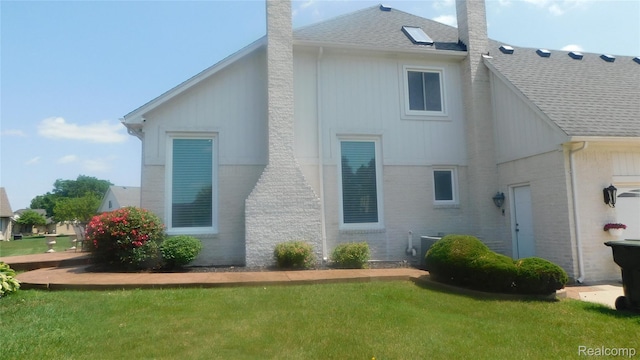 41431 Tarragon Dr, Sterling Heights, MI 48314 - back of house with a chimney, roof with shingles, a lawn, and brick siding
