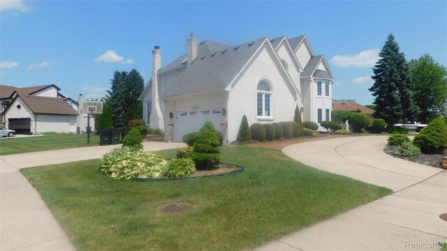 41431 Tarragon Dr, Sterling Heights, MI 48314 - view of home's exterior with curved driveway, a garage, a lawn, a chimney, and brick siding