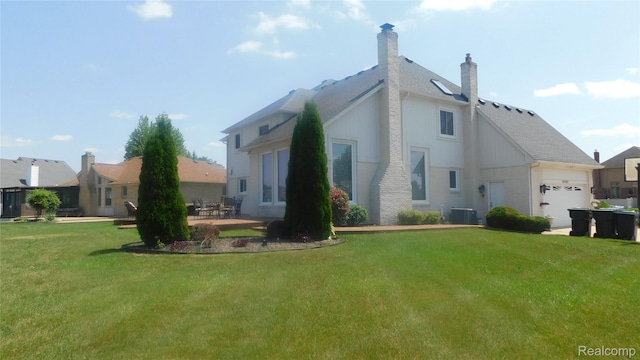 41431 Tarragon Dr, Sterling Heights, MI 48314 - back of house with a lawn, an attached garage, a chimney, and a shingled roof