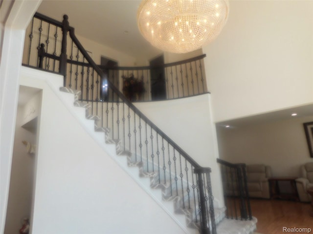41431 Tarragon Dr, Sterling Heights, MI 48314 - staircase with a chandelier, a towering ceiling, and wood finished floors