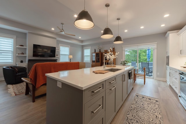 5332 Harborview Pass, Kalamazoo, MI 49009 - kitchen with light wood-style flooring, an island with sink, light countertops, gray cabinets, and white cabinets