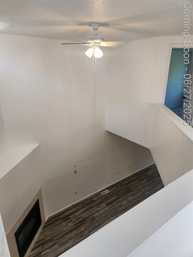 361 Irons Park Dr, West Branch, MI 48661 - staircase with wood finished floors, ceiling fan, a textured ceiling, and a fireplace