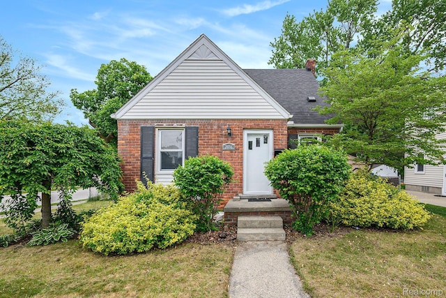 2856 Academy St, Dearborn, MI 48124 - bungalow-style house with brick siding, a shingled roof, a chimney, and a front yard