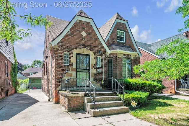 2675 Fleet St, Detroit, MI 48238 - tudor home with brick siding, a gate, and a shingled roof