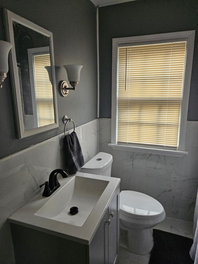 6303 Guilford St, Detroit, MI 48224 - bathroom with tile walls, vanity, wainscoting, and marble look tiles