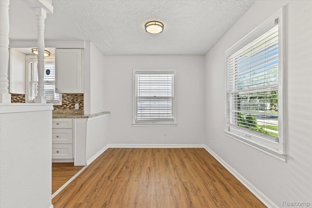 21525 Syracuse Ave, Warren, MI 48091 - unfurnished dining area with wood finished floors, plenty of natural light, and a textured ceiling