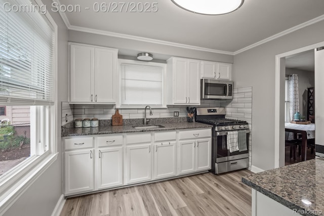 94 S Tilden Ave, Waterford, MI 48328 - kitchen featuring appliances with stainless steel finishes, white cabinets, healthy amount of natural light, decorative backsplash, and crown molding