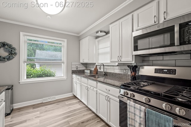 94 S Tilden Ave, Waterford, MI 48328 - kitchen with stainless steel appliances, ornamental molding, white cabinetry, dark stone countertops, and decorative backsplash