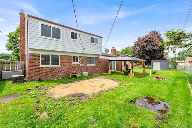 14717 Dane Ct, Sterling Heights, MI 48312 - rear view of property featuring a gazebo, a chimney, and brick siding