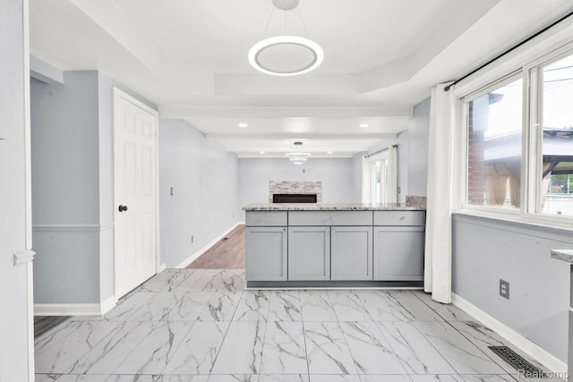 14717 Dane Ct, Sterling Heights, MI 48312 - kitchen featuring gray cabinetry, a tray ceiling, light marble finish flooring, light stone counters, and recessed lighting