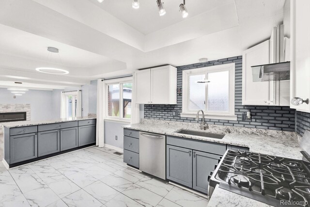 14717 Dane Ct, Sterling Heights, MI 48312 - kitchen featuring stainless steel appliances, a tray ceiling, backsplash, light stone countertops, and white cabinetry