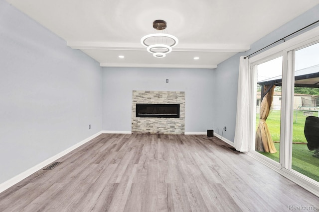 14717 Dane Ct, Sterling Heights, MI 48312 - unfurnished living room with beam ceiling, wood finished floors, a stone fireplace, a chandelier, and recessed lighting