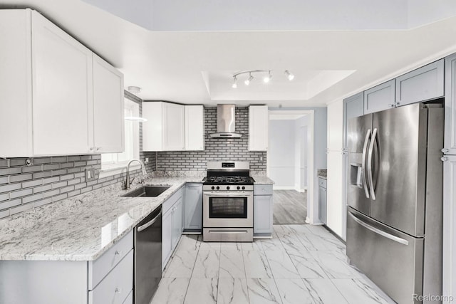 14717 Dane Ct, Sterling Heights, MI 48312 - kitchen featuring stainless steel appliances, wall chimney exhaust hood, a tray ceiling, light marble finish flooring, and tasteful backsplash