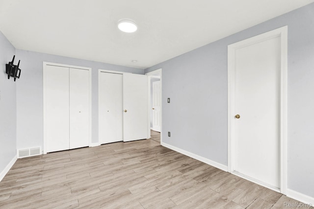 14717 Dane Ct, Sterling Heights, MI 48312 - unfurnished bedroom featuring multiple closets and wood finished floors