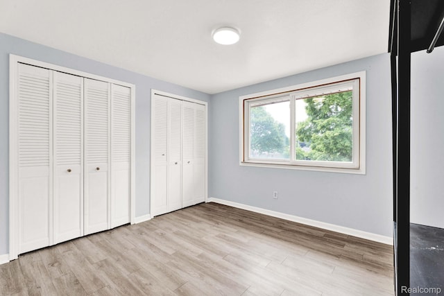 14717 Dane Ct, Sterling Heights, MI 48312 - unfurnished bedroom featuring two closets and light wood-style floors