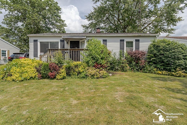 1151 July Dr, Adrian, MI 49221 - view of front facade featuring a chimney and a front lawn