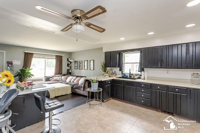 1151 July Dr, Adrian, MI 49221 - kitchen featuring ceiling fan, light countertops, open floor plan, dark cabinets, and recessed lighting