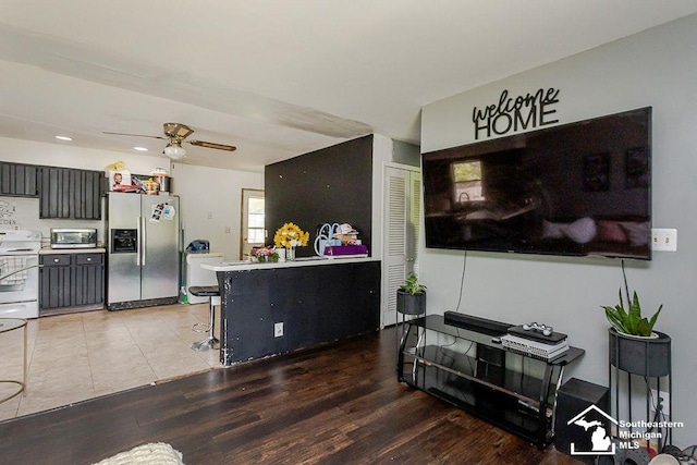 1151 July Dr, Adrian, MI 49221 - kitchen featuring stainless steel appliances, a ceiling fan, wood finished floors, a breakfast bar, and recessed lighting