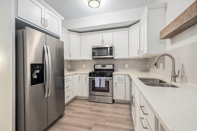 2005 Celadon Dr NE Unit 12, Grand Rapids, MI 49525 - kitchen with stainless steel appliances, white cabinets, and decorative backsplash