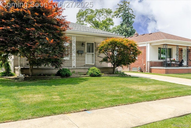 14711 Paris St, Allen Park, MI 48101 - view of front of home featuring covered porch, brick siding, and a front lawn