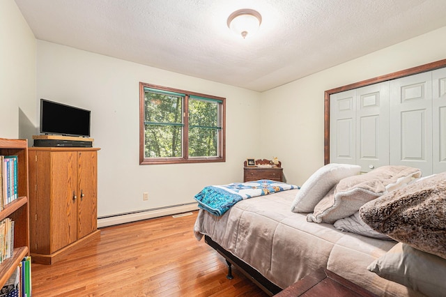 4234 N 2nd St, Kalamazoo, MI 49009 - bedroom with a baseboard heating unit, light wood-type flooring, and a closet