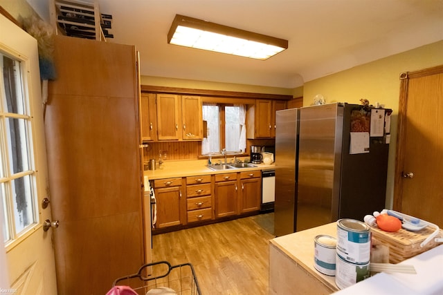 615 Saginaw St, Vassar, MI 48768 - kitchen with freestanding refrigerator, brown cabinetry, light wood-style floors, light countertops, and dishwasher