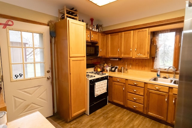 615 Saginaw St, Vassar, MI 48768 - kitchen featuring gas range oven, black microwave, light countertops, and plenty of natural light