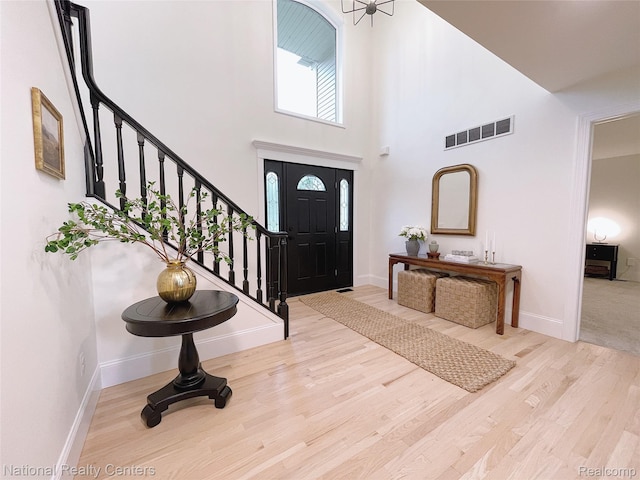 5403 Lenard Cir, Howell, MI 48843 - entrance foyer featuring stairway, a towering ceiling, and wood finished floors