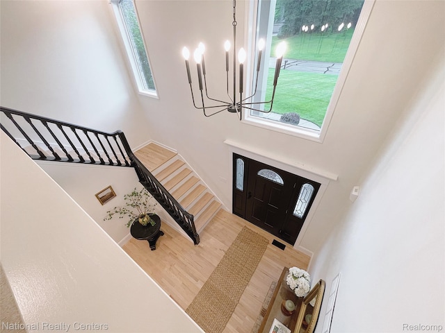 5403 Lenard Cir, Howell, MI 48843 - foyer entrance featuring a chandelier, stairs, wood finished floors, and a high ceiling