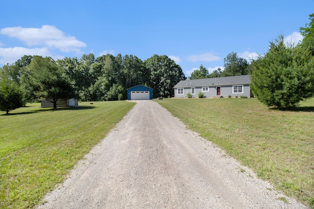 6127 River Rd, Manistee, MI 49660 - single story home featuring an outbuilding, a detached garage, a front lawn, and dirt driveway