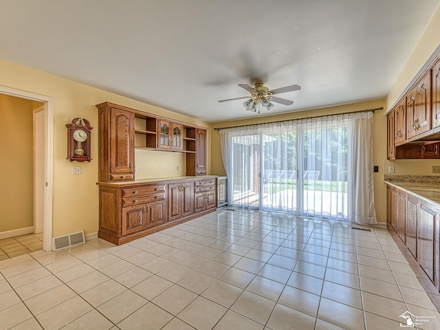255 Maywood Ave, Monroe, MI 48162 - kitchen featuring light tile patterned floors, open shelves, a ceiling fan, and brown cabinets