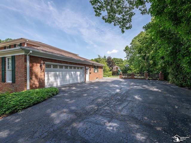 255 Maywood Ave, Monroe, MI 48162 - view of home's exterior featuring asphalt driveway, brick siding, and a garage